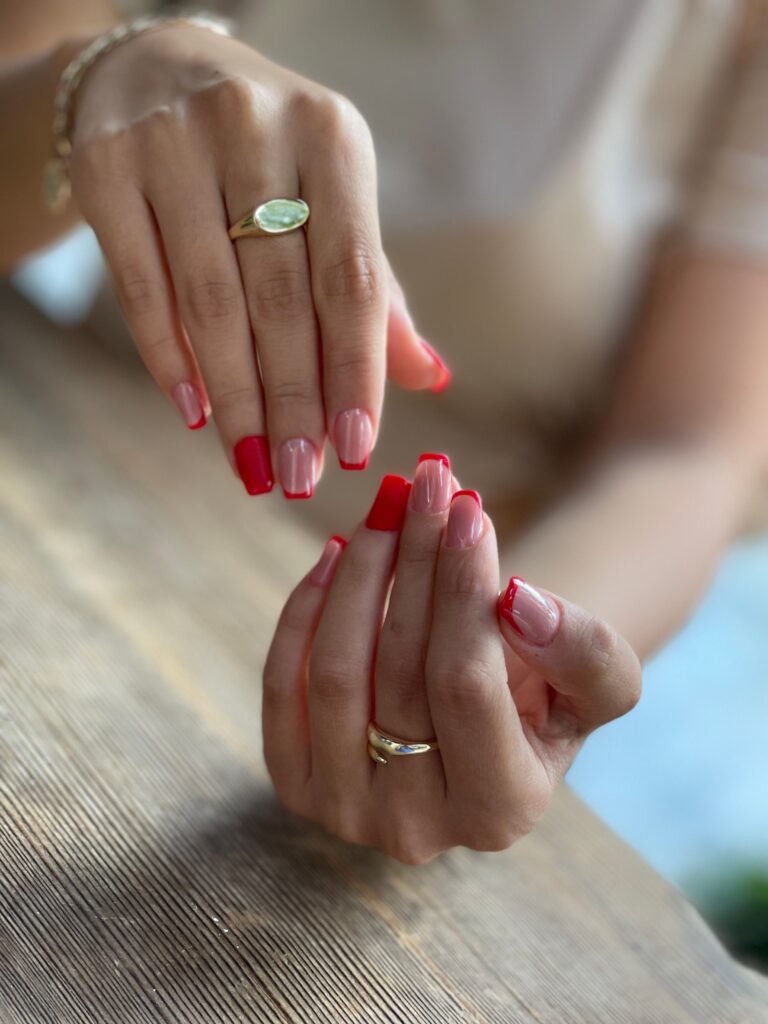 Modern French manicure with glossy red nail polish